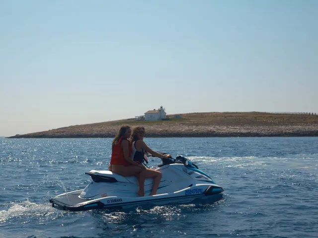 Jet ski action near a small lighthouse