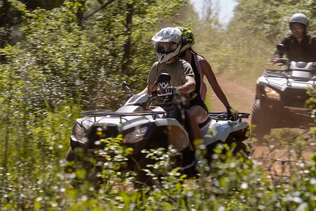 Close-up of a quad rider kicking up dust