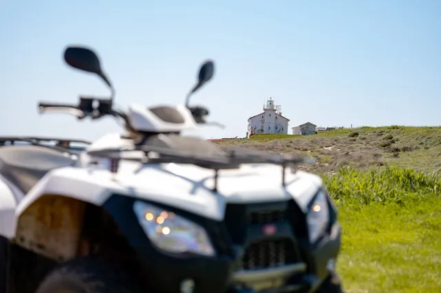 White quad with a coastal lighthouse beyond