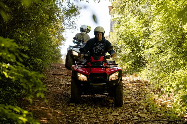 Quads on a rocky forest trail, lead rider